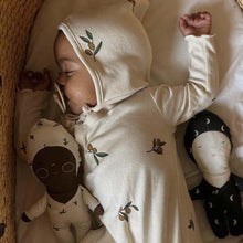 Baby sleeping surrounded by Zoonie dolls